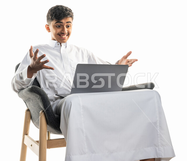 بورتريه لولد عربي سعودي خليجي ، يجلس على كرسي ،   إستخدام جهاز الحاسوب المحمول ، إجراء مكالمة فيديو ، بث مباشر ، التواصل مع الأصدقاء ، تصفح الإنترنت ، محادثات ودردشة ، التعليم الإلكتروني ، خلفية بيضاء