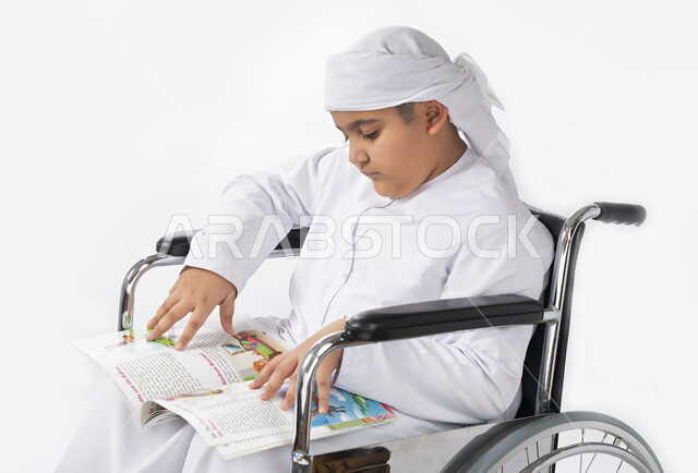 بورتريه لطفل عربي إماراتي خليجي يرتدي الزي التقليدي من ذوي الهمم يجلس على كرسي متحرك يؤدي فروضه المدرسية  , التمكين الاجتماعي, اهتمام ودعم المجتمع الإماراتي لذوي الاحتياجات الخاصه, التعليم المنزلي , تعليم عن بعد , خلفية بيضاء 