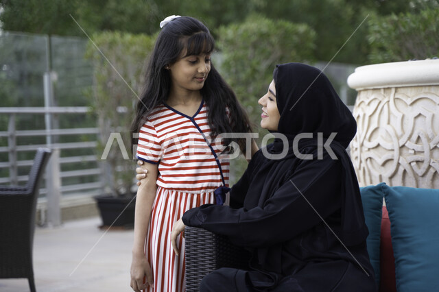 التسامر و الضحك بين الأم وابنتها، مفهوم الأمومة والعطف والحنان، أجواء مليئة بالحب والسعادة بجلسة عائلية راقية، فتاة عربية اماراتية خليجية تستمتع برفقة والدتها بالأجواء الصيفيه في أحد المقاهي، ام سعودية محجبة تقضي أوقات ممتعه مع ابنتها