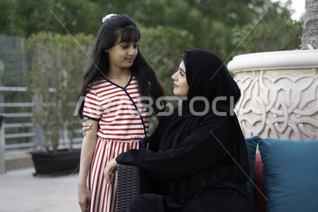 تبادل الاحاديث بين الأم وابنتها، مفهوم الأمومة والعطف و الحنان، أجواء مليئة بالحب والسعادة بجلسة عائلية راقية، فتاة عربية اماراتية خليجية تستمتع برفقة والدتها بالأجواء الصيفيه في أحد المقاهي، ام سعودية محجبة تقضي أوقات ممتعه مع ابنتها في الخارج