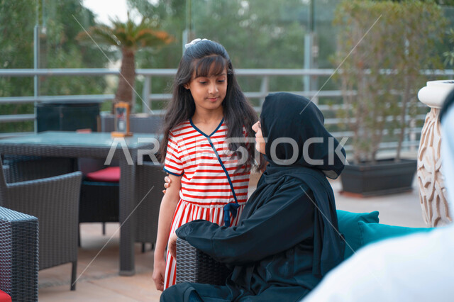 أجواء مليئة بالحب والسعادة بجلسة عائلية راقية، مفهوم الأمومة والعطف و الحنان، فتاة عربية اماراتية خليجية تستمتع برفقة والدتها بالأجواء الصيفيه في أحد المقاهي، ام سعودية محجبة تقضي أوقات ممتعه مع ابنتها في الخارج