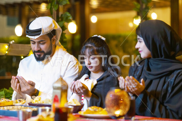 سفرة إفطار مليئة بأصناف المأكولات والمقبلات الشهية, عائلة عربية خليجية إماراتية تجلس على مائدة الطعام وتدعو الله عند موعد الإفطار في شهر رمضان المبارك, اسلاميات وعبادات، فضل الدعاء وقت أذان المغرب، أسرة سعودية تستعد لتناول الطعام في إحدى المطاعم الفاخرة