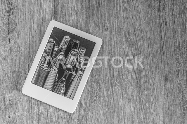 Tablet on a wooden background, modern e-reader, advanced modern devices, technology and technology, wooden background