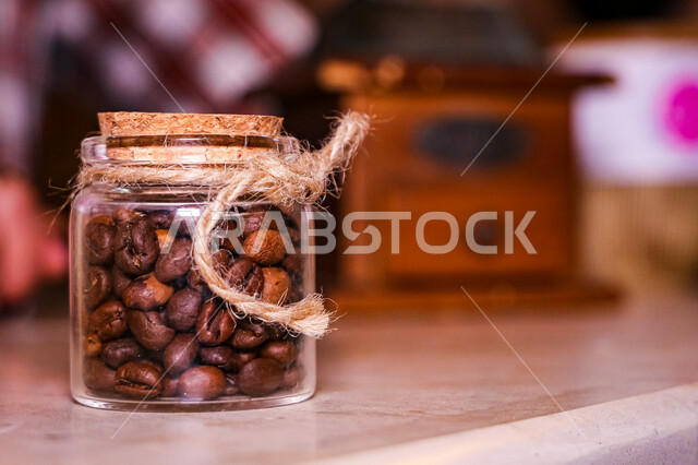 تصوير مقرب لعلبة زجاجيه مليئه بحبوب البن المحمص, حبوب القهوة الطازجه السوداء, مقاهي وكافيهات