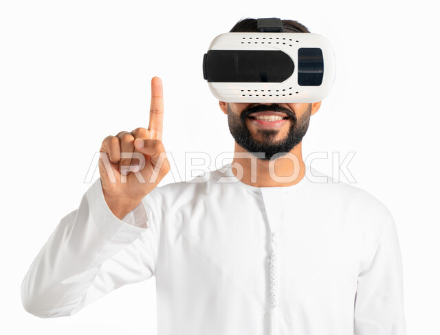 حركة اصبع وإشارات، الضغط والنقر وإستخدام حاسة اللمس، بورتريه لرجل إماراتي عربي خليجي يرتدي الكندورة الإماراتية ونظارات في آر ثلاثية الإبعاد ويشير بأصبع السبابة لشئ ما يشاهده بالواقع الإفتراضي، محاكاة العالم الافتراضي، خلفية بيضاء