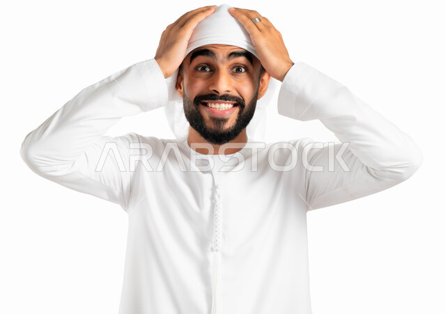 إيماءات وجه ويدين تدل الدهشة والذهول، بورتريه لرجل عربي خليجي إماراتي يرتدي العمامة والكندورة الإماراتية ويضع يده على رأسه، التعجب والإستغراب والصدمة، خلفية بيضاء