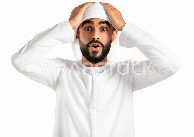 التعجب والإستغراب والصدمة، بورتريه لرجل عربي خليجي إماراتي يرتدي العمامة والكندورة الإماراتية ويضع يده على رأسه، إيماءات وجه ويدين تدل الدهشة والذهول، خلفية بيضاء