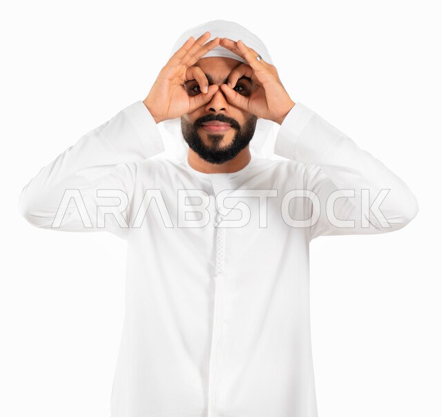 الأهداف والطموحات والرؤية المستقبلية، بورتريه لرجل عربي خليجي إماراتي يرتدي العمامة والكندورة الإماراتية ويضع يده على عينيه كالناظور، الاستكشاف و المغامرة مع فريق الكشافة، البحث والتخطيط والنظر للمستقبل، خلفية بيضاء