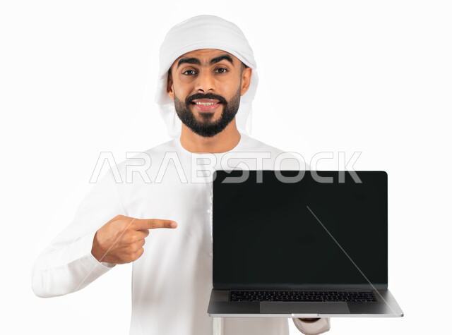 Displaying web pages, programs and electronic applications, a portrait of an Arab Gulf Emirati man wearing a turban and an Emirati kandora and holding a laptop with a blank black screen, advertising, entertainment and e-marketing, white background