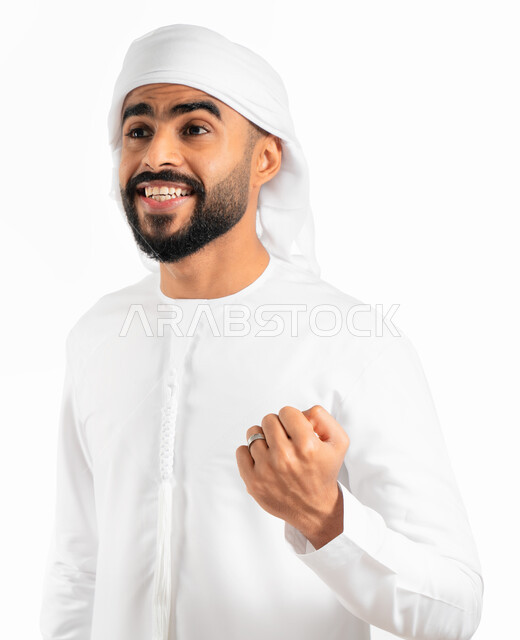 الفرح والسعادة بالفوز والإنتصار، بورتريه لرجل عربي خليجي إماراتي يرتدي العمامة والكندورة الإماراتية، إيماءات يدين تدل على الحماس والشغف، المنافسة والتحدي والتشجيع، النجاح والقوة وتحقيق الاهداف، خلفية بيضاء