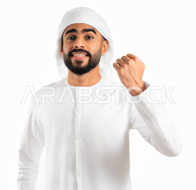 إيماءات يدين تدل على الحماس والشغف، بورتريه لرجل عربي خليجي إماراتي يرتدي العمامة والكندورة الإماراتية، المنافسة والتحدي والتشجيع، الفرح والسعادة بالفوز والإنتصار، النجاح والقوة وتحقيق الاهداف، خلفية بيضاء