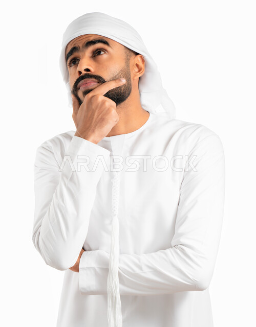 Meditation, meditation and planning for the future, a portrait of an Emirati Gulf Arab man wearing an Emirati kandora and turban and placing his hand on his chin, gestures of thinking, confusion and focus in solving problems, future vision, white backgrou