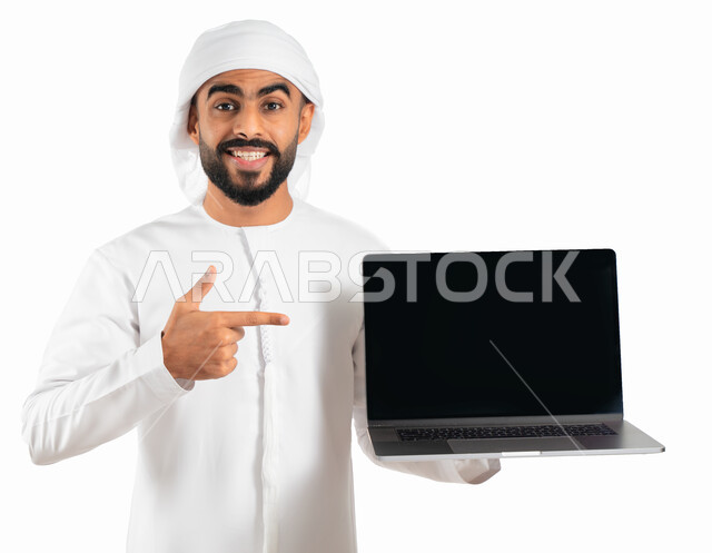 Advertising, entertainment and e-marketing, a portrait of an Arab Gulf Emirati man wearing a turban and an Emirati kandoora and holding a laptop with a blank black screen, displaying web pages, electronic programs and applications, white background