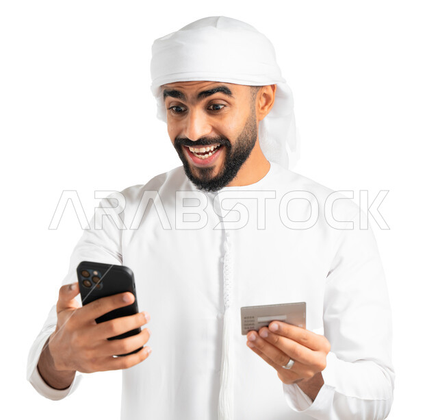 إمكانية تسديد الفواتير بالبطاقة الإلكترونية، بورتريه لرجل عربي خليجي إماراتي يرتدي الكندورة والعمامة الإماراتية ويمسك بيده الهاتف المحمول وبطاقة الإئتمان البنكية، الشراء والدفع من خلال برامج وتطبيقات الجوال، إيماءات الدهشة والذهول، خلفية بيضاء