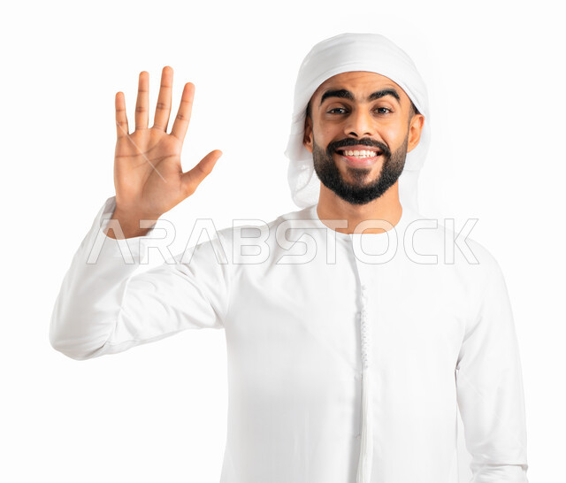 حركة يد وإشارات، التحية والسلام والترحيب بشخص ما، بورتريه لرجل عربي خليجي إماراتي يرتدي الكندورة والعمامة الإماراتية ويرفع يده بإشارة الترحيب، إيماءات السعادة والبهجة والسرور، خلفية بيضاء