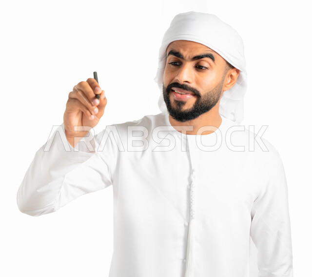 الاستعداد لكتابة وتحديد شيء ما، بورتريه لرجل عربي خليجي إماراتي يرتدي العمامة والكندورة الإماراتية البيضاء ويمسك بيده قلم، الرسم والتخطيط والإشارة بالقلم على الهواء، خلفية بيضاء