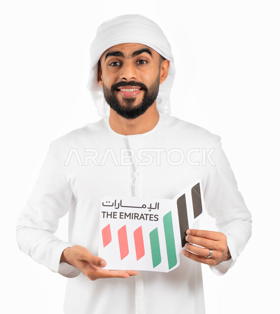 إحياء ذكرى العيد الوطني الإماراتي، بورتريه لرجل إماراتي عربي خليجي يرتدي الكندورة والعمامة الإماراتية ويحمل بيده شعار على شكل خريطة الإمارات العربية المتحدة ملون بألوان العلم الإماراتي، الإحتفال بيوم توحيد وإستقلال الإمارات، خلفية بيضاء