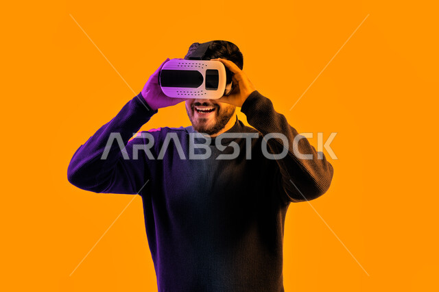 Interacting with the movie and simulating the imaginary world, a smiling Saudi man watching movies through VR glasses, a close-up portrait of an Emirati Arab Gulf man wearing casual clothes and 3D virtual reality glasses, gestures indicating happiness and