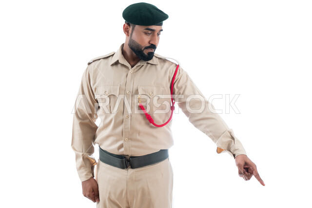 الإستجابة لحالات الطوارئ، بورتريه لشرطي عربي خليجي إماراتي يرتدي الزي العسكري ويشير بإصبع السبابة نحو شيء ما، حركة إصبع وإشارات، تعزيز الأمن والأمان والثقة بالشرطة، تأمين المنشأت وحماية الأفراد، خلفية بيضاء