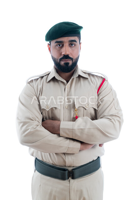 العمل على خفض معدلات الجريمة، بورتريه لشرطي عربي خليجي إماراتي يرتدي البدلة العسكرية بأيدي متقاطعة، الوقوف بإستقامة وإنضباط، تعزيز الأمن والأمان والثقة بالشرطة، إيماءات وجه ويدين تدل على الثقة، إدارة الأزمات والكوراث، خلفية بيضاء