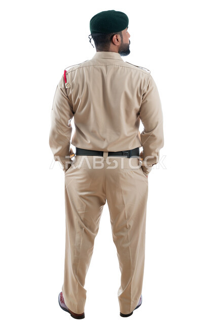 الإستجابة لحالات الطوارئ، إدارة الأزمات والكوراث، بورتريه من الخلف لشرطي عربي خليجي إماراتي يرتدي البدلة العسكرية، تعزيز الأمن والأمان والثقة بالشرطة، العمل على خفض معدلات الجريمة، صورة الجسم بالطول الكامل، خلفية بيضاء