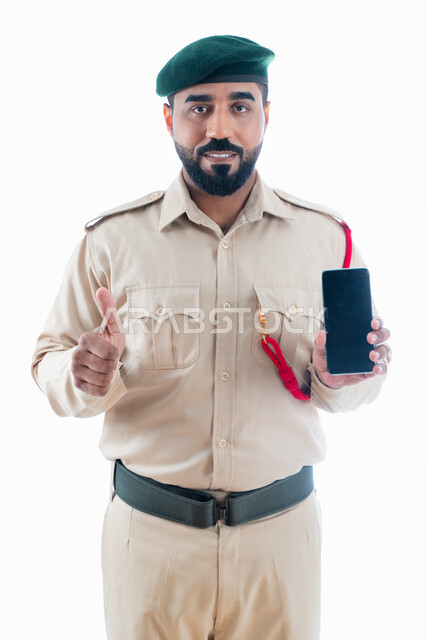 الإستخدام السليم لتطبيقات الهاتف المحمول، إيماءات إبهام لأعلى، بورتريه لرجل أمن عربي إماراتي خليجي يرتدي بدلة الشرطة الرسمية، إتباع قوانين الجرائم الإلكترونية، مكافحة الاحتيال وسرقة البيانات المالية، الحفاظ على أمن المعلومات الشخصية، خلفية بيضاء