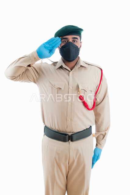 جمع المعلومات والأدلة لكشف الحقائق والجرائم، الوقوف بإستقامة وإنضباط، بورتريه لمحقق جنائي عربي خليجي إماراتي يرتدي الكمامة الواقية والقفازات وبدلة الشرطة الرسمية ويقوم بإلقاء التحية العسكرية، البحث والتحري في موقع الجريمة، خلفية بيضاء