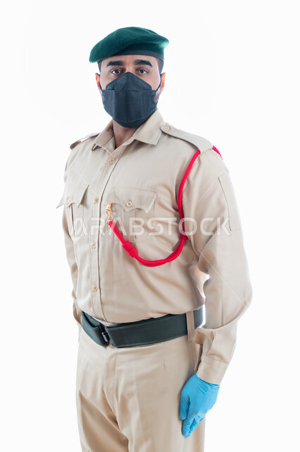 تعزيز الأمن والأمان والثقة بالشرطة، جمع الأدلة للتحقق والتحري في موقع الجريمة، بورتريه لمحقق جنائي عربي خليجي إماراتي يرتدي الكمامة الواقية والقفازات وبدلة الشرطة الرسمية ويقف بإستقامة وإنضباط وإستعداد، البحث لكشف حقائق الجرائم، خلفية بيضاء