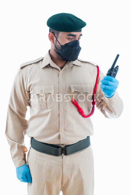 تأمين المنشأت وحماية الأفراد، بورتريه  لمحقق جنائي إماراتي عربي خليجي يرتدي بدلة الشرطة الرسمية ويستخدم جهاز الإرسال والإستقبال اللاسلكي في التواصل مع فريف البحث في موقع الجريمة، تعزيز الأمن والأمان والثقة بالشرطة، إدارة الأزمات والكوراث، خلفية بيضاء