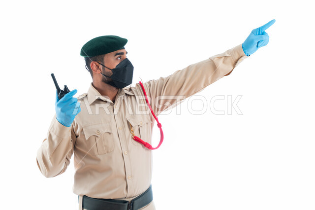 التواصل مع فريف البحث والتحري في موقع الجريمة من خلال جهاز الإرسال والإستقبال اللاسلكي، بورتريه لمحقق جنائي عربي خليجي إماراتي يرتدي بدلة الشرطة الرسمية ويشير بإصبع السبابة نحو شيء ما، جمع المعلومات والأدلة لكشف الحقائق والجرائم، خلفية بيضاء