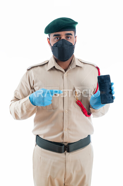 الإشارة بإصبع السبابة نحو الجوال بشاشة سوداء فارغة، برامج وانظمة حماية الهاتف المحمول، بورتريه بورتريه لمحقق أدلة جنائية عربي خليجي إماراتي يرتدي الكمامة الواقية والقفازات وبدلة الشرطة الرسمية، إستخدام تطبيقات الأمن والسلامة في الهاتف الذكي، خلفية بيضاء