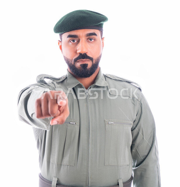 تأمين المنشأت وحماية الأفراد، تعزيز الأمن والأمان والثقة بالشرطة، بورتريه لرجل أمن عربي خليجي إماراتي يرتدي بدلة الأمن الخضراء ويشير بإصبع السبابة نحو شيء ما، حركة إصبع وإشارات، إدارة الأزمات والكوراث، خلفية بيضاء