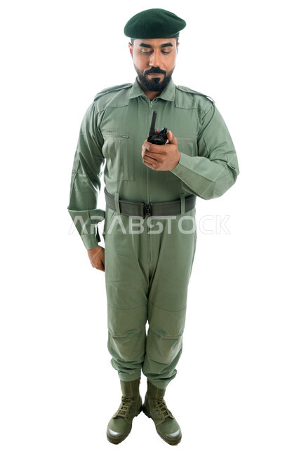 تأمين المنشأت وحماية الأفراد، بورتريه لرجل أمن عربي خليجي إماراتي يرتدي بدلة الأمن الخضراء ويستخدم جهاز الإرسال والإستقبال اللاسلكي، الإستجابة لحالات الطوارئ، إدارة الأزمات والكوراث، صورة الجسم بالطول الكامل، خلفية بيضاء
