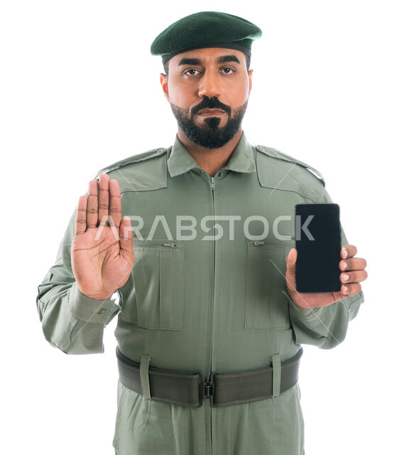 عدم قبول الإشاعات وكشف الجرائم المعلوماتية، بورتريه لرجل امن عربي إماراتي خليجي يرتدي بدلة الأمن الخضراء، إيماءات يد تدل على التوقف، برامج وانظمة حماية الهاتف المحمول، التوقف عن الاستخدام السيء للجوال والمخالفات الالكترونية، خلفية بيضاء