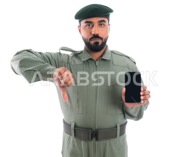 الاستخدام السيء للجوال والمخالفات الالكترونية، بورتريه لرجل أمن عربي إماراتي خليجي يرتدي بدلة الأمن الخضراء، إيماءات إبهام لأسفل تدل على الرفض والإستياء، مكافحة الإشاعات الكاذبة وكشف الجرائم المعلوماتية، برامج  وانظمة حماية الهاتف المحمول، خلفية بيضاء