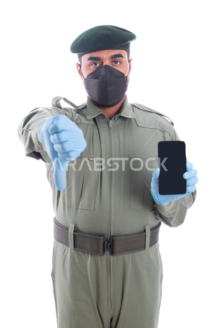 إيماءات إبهام لأسفل تدل على الرفض والإستياء، بورتريه لمحقق أدلة جنائية عربي خليجي إماراتي يرتدي الكمامة الواقية والقفازات وبدلة الأمن الخضراء، مكافحة الإشاعات الكاذبة وكشف الجرائم المعلوماتية، الإستخدام السيء للجوال والمخالفات الالكترونية، خلفية بيضاء