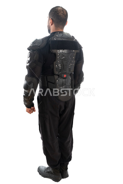 قوات التدخل السريع (سوات)، بورتريه من الخلف لشرطي عربي خليجي إماراتي يرتدي البدلة العسكرية السوداء، الحفاظ على الأمن والأمان، الوقوف باستعداد وانضباط، صورة الجسم بالطول الكامل، خلفية بيضاء
