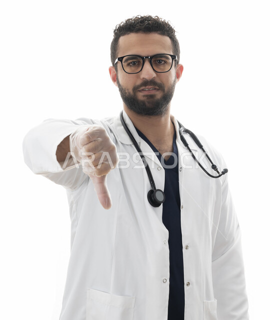 الاشارة بإصبع الإبهام الى الاسفل لمنع انتشار الفايروس، ارتداء النظارة الطبيه و المعطف الطبي وسماعه الطبيب لسماع نبضات القلب, بورتريه مقرب لطبيب سعودي يعمل في القطاع الصحي، شاب عربي اماراتي خليجي يوضح مفهوم الطب والرعاية الصحية, مهن ووظائف طبيه