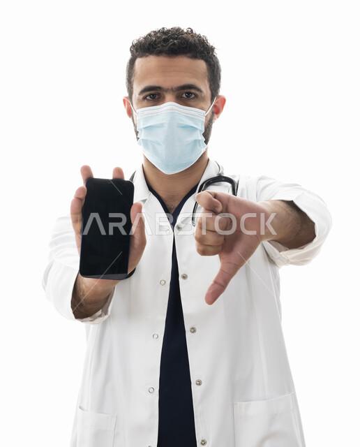 عرض شاشه سوداء فارغه عبر الجوال ،بورتريه مقرب لطبيب سعودي يتبع توصيات وزارة الصحة للحفاظ على السلامة, شاب عربي اماراتي خليجي يشير بإصبعه الابهام للاسفل لمنع استخدام الجوال, مهن ووظائف طبية في القطاع الصحي ،تقديم الخدمات للمرضى بكل كفاءه