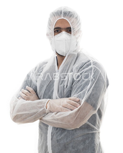 الوقوف بأيدي متقاطعة , بورتريه مقرب  لطبيب سعودي يرتدي اللباس الأبيض العازل الواقي لمكافحة فايروس كورونا, شاب عربي اماراتي خليجي يقوم بإتباع توصيات وزارة الصحة في الحفاظ على السلامة, الالتزام بالاحترازات والإجراءات الوقائيه ضد كوفيد 19