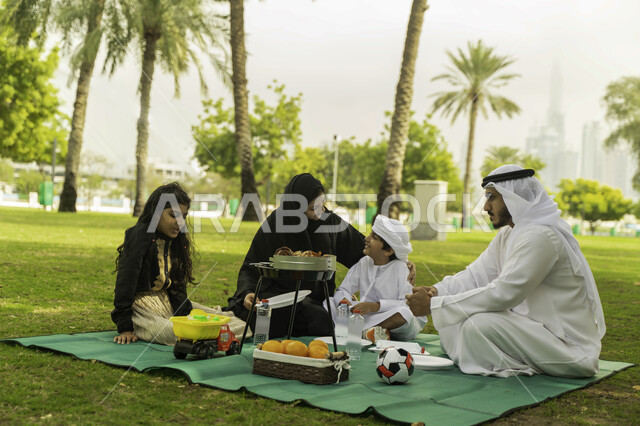 الاصغاء الى أحاديث الاولاد في الحدائق, لمة الاسره السعيدة, نزهه في الهواء الطلق, عائلة عربية اماراتية خليجية في إحدى المنتزهات في الخارج, عائلة سعودية تقضي أوقات ممتعه مع الابناء, الاعتناء بالأطفال والاهتمام بهم, انشطة ترفيهيه صيفية