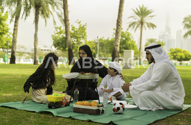 لمة الاسره السعيدة, الاصغاء الى أحاديث الاولاد في الحدائق, نزهه في الهواء الطلق, عائلة عربية اماراتية خليجية في إحدى المنتزهات في الخارج, عائلة سعودية تقضي أوقات ممتعه مع الابناء, الاعتناء بالأطفال والاهتمام بهم, انشطة ترفيهيه صيفية