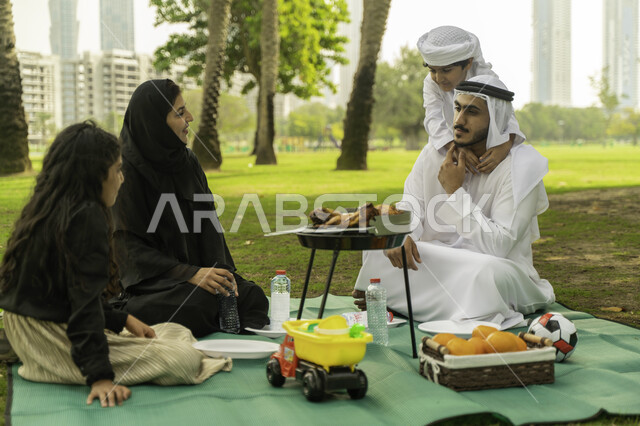 مفهوم الترابط الأسري, قضاء أوقات ممتعه في الحديقة، جلسات عائلية في الطبيعه الخضراء، الخروج مع الاطفال في العطلة الصيفيه، رحلة في أجواء ربيعيه، أجواء عائلية مليئة بالحب، عائلة عربية اماراتية خليجية في إحدى المزارع, عائلة سعودية تقوم بالتحضير للشواء