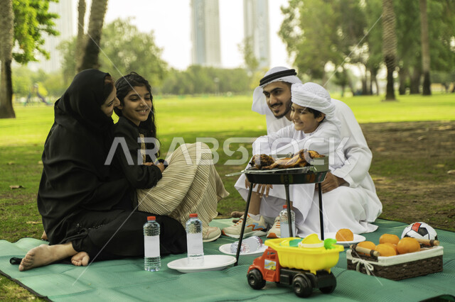 The concept of parenting with love and tenderness, communicating and laughing with children, going out with children on summer vacation, a trip in a spring atmosphere, a family atmosphere full of love, an Arab Emirati Gulf family on a farm, a Saudi family