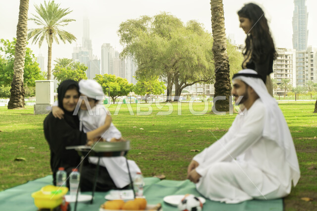 تجمع عائلي سعيد, الاهتمام والاعتناء بالأطفال، رحلة في أجواء ربيعيه في الخارج, مفهوم الامومة والتربية بالعطف و الحنان، أجواء عائلية مليئة بالحب، صورة مقربة لعائلة عربية اماراتية خليجية في إحدى المنتزهات, عائلة سعودية تقضي أوقات ممتعه في الحديقة