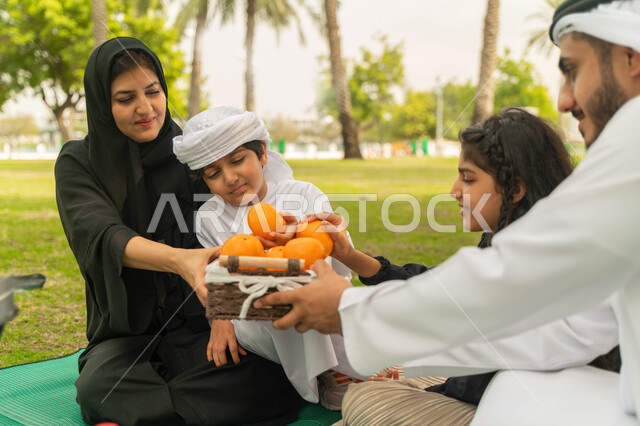 A trip in a spring atmosphere abroad, a local Saudi national product, a healthy healthy snack, a family atmosphere full of love, an Arab Emirati Gulf family in a park, sharing delicious, fresh and refreshing fruits among family members, a Saudi family spe