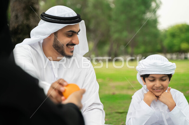 التسامر والضحك بين افراد العائلة, منتج محلي سعودي وطني ،سناك مفيد صحي، أجواء عائلية مليئة بالحب، عائلة عربية اماراتية خليجية في إحدى الحدائق الغناء، مشاركة الفواكه اللذيذة الطازجة المنعشة , عائلة سعودية تقضي أوقات ممتعه في الخارج, نزهه في الهواء الطلق