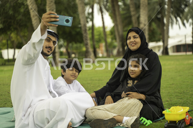 انشطة صيفية ترفيهيه, التقاط صور السيلفي للذكريات و التجمعات العائلية الودية عبر الجوال, عائلة عربية اماراتية خليجية في إحدى الحدائق والمنتزهات في الخارج, عائلة سعودية تقضي أوقات ممتعه مع الابناء, الاعتناء بالأطفال والاهتمام بهم, التنزه في الهواء الطلق