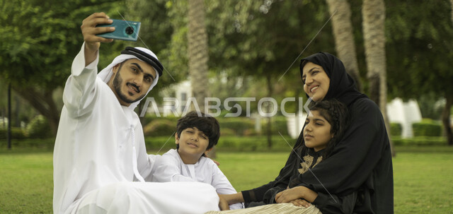 الاهتمام بالأطفال والاعتناء بهم, التقاط صور السيلفي للذكريات و التجمعات العائلية الودية عبر الجوال, عائلة عربية اماراتية خليجية في إحدى الحدائق والمنتزهات في الخارج, عائلة سعودية تقضي أوقات ممتعه مع الابناء, انشطة ترفيهيه صيفية, التنزه في الهواء الطلق