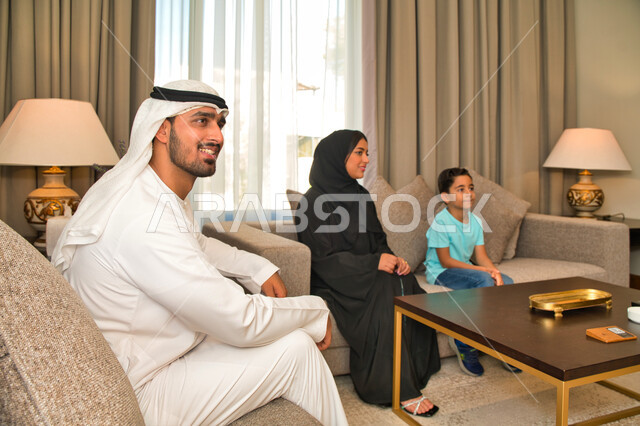 تعابير وجه تدل على الإندماج والتركيز، أجواء منزليه هادئه، أسره عربيه خليجيه اماراتيه تقوم بمشاهدة التلفاز، مفهوم العائله السعوديه المترابطه، قضاء أوقات ممتعة برفقه الأهل في أوقات الفراغ، متابعه الأفلام والمسلسلات والبرامج التلفزيونيه.
